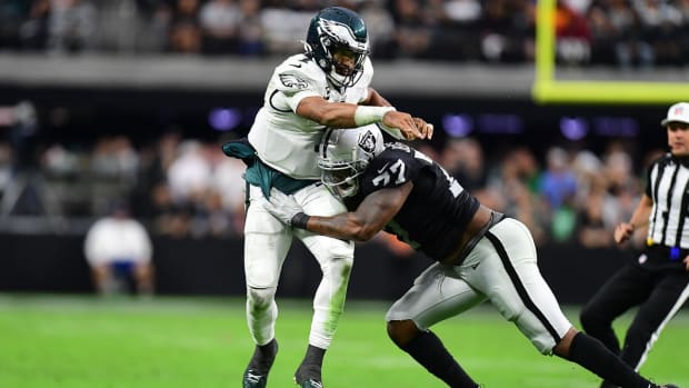 Oct 24, 2021; Paradise, Nevada, USA; Philadelphia Eagles quarterback Jalen Hurts (1) throws under pressure from Las Vegas Raiders defensive tackle Quinton Jefferson (77) during the second half at Allegiant Stadium. Mandatory Credit: Gary A. Vasquez-USA TODAY Sports